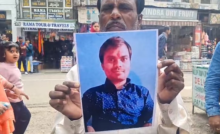 Father of Durgesh holding a picture of his son, who went missing in Katra.